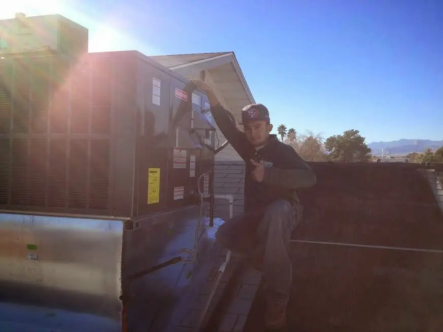 HVAC technician performing Boiler Repair on a rooftop unit in Schererville